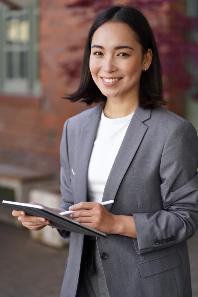 Young business woman smiles while holding a tablet